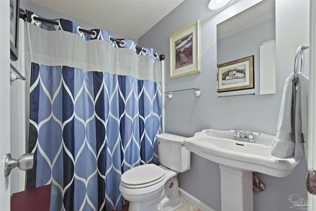 bathroom featuring baseboards, curtained shower, a textured ceiling, and toilet