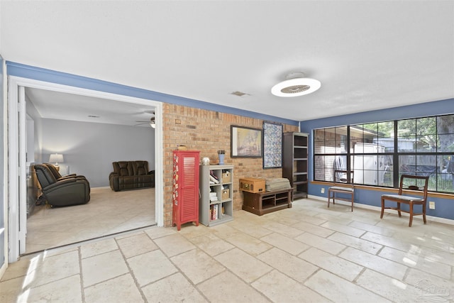 living area with stone tile floors, a ceiling fan, baseboards, and visible vents