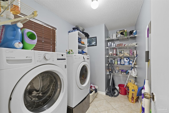 clothes washing area featuring separate washer and dryer, a textured ceiling, tile patterned flooring, and laundry area