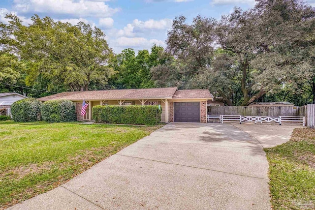 single story home with concrete driveway, an attached garage, fence, a front yard, and brick siding