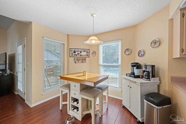 dining room featuring dark hardwood / wood-style flooring and a textured ceiling