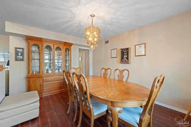 dining area with a chandelier and a textured ceiling