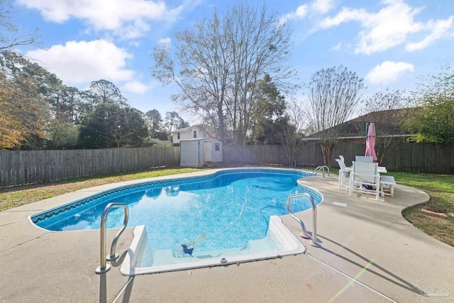 view of swimming pool featuring a storage shed and a patio area