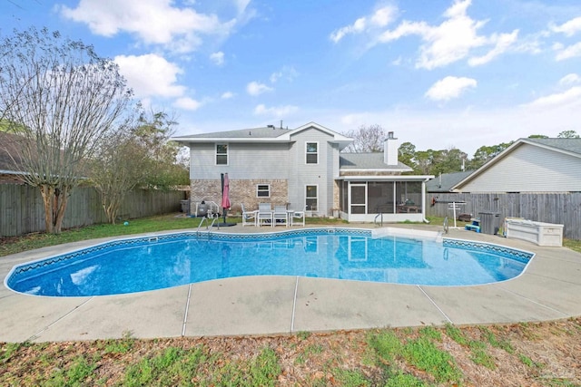 view of swimming pool with a patio area and a sunroom