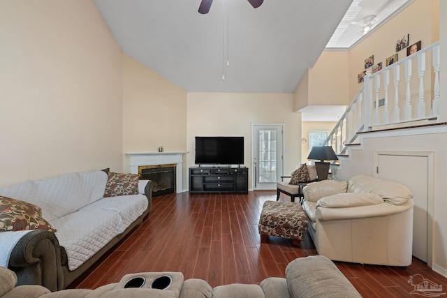 living room with dark wood-type flooring, high vaulted ceiling, and ceiling fan