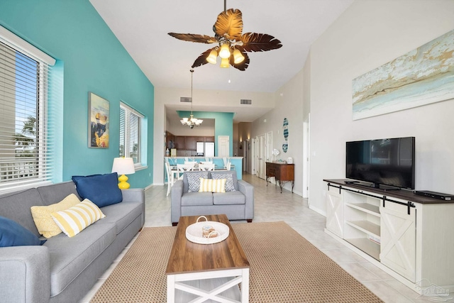 tiled living room with ceiling fan with notable chandelier