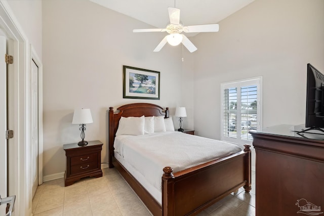 bedroom with light tile patterned floors, ceiling fan, and a high ceiling