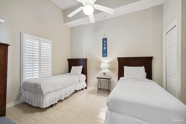 bedroom featuring ceiling fan, a closet, and light tile patterned floors