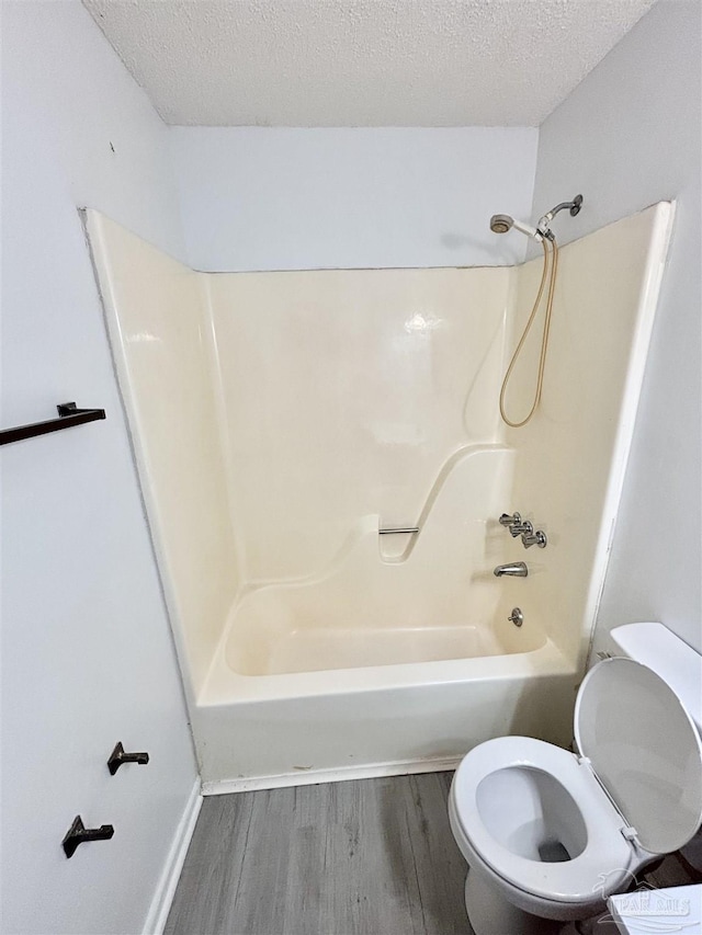 5737 Chumuckla Hwy, Pace, FL 32571 - full bath with wood finished floors, toilet, a textured ceiling, shower / washtub combination, and baseboards
