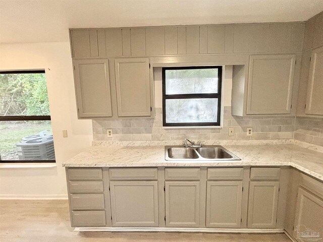 5737 Chumuckla Hwy, Pace, FL 32571 - kitchen with a sink, light wood-type flooring, decorative backsplash, and baseboards