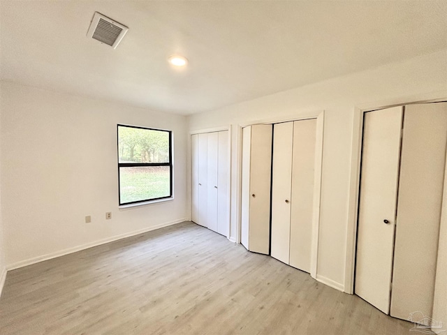 5737 Chumuckla Hwy, Pace, FL 32571 - unfurnished bedroom with two closets, light wood finished floors, baseboards, and recessed lighting