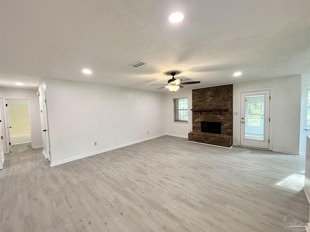 5737 Chumuckla Hwy, Pace, FL 32571 - unfurnished living room with ceiling fan, a brick fireplace, light wood-type flooring, recessed lighting, and a textured ceiling