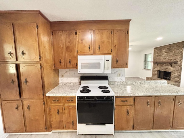5737 Chumuckla Hwy, Pace, FL 32571 - kitchen with white appliances, brown cabinets, a fireplace, and a peninsula