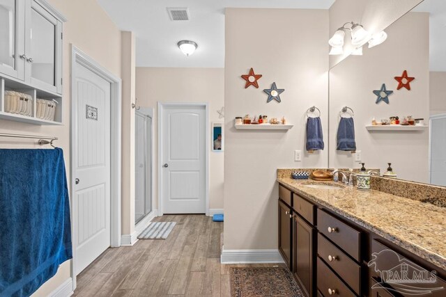 bathroom featuring vanity, hardwood / wood-style floors, and walk in shower