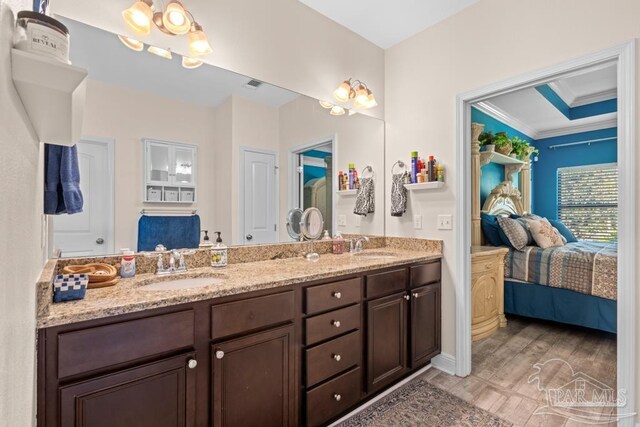 bathroom with vanity, crown molding, and hardwood / wood-style flooring