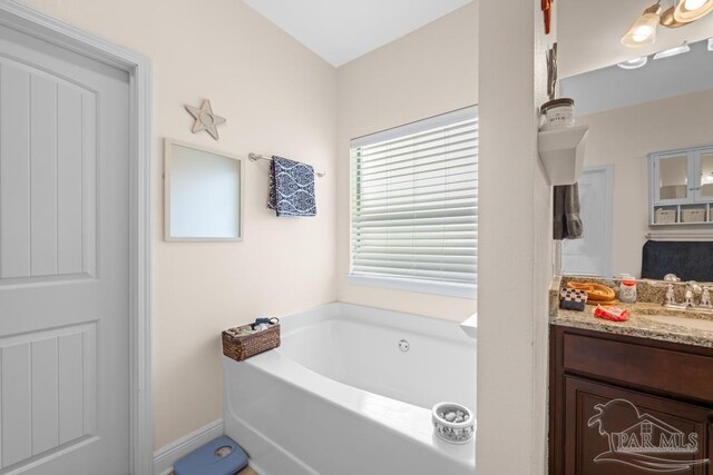 bathroom with vanity and a tub