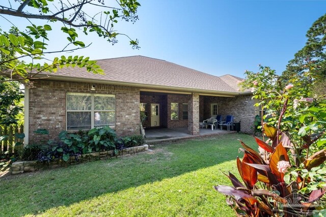 rear view of property featuring a yard and a patio