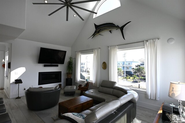 living room with ceiling fan, wood-type flooring, and high vaulted ceiling