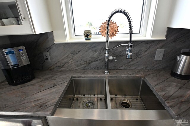 details featuring backsplash, white cabinetry, and sink