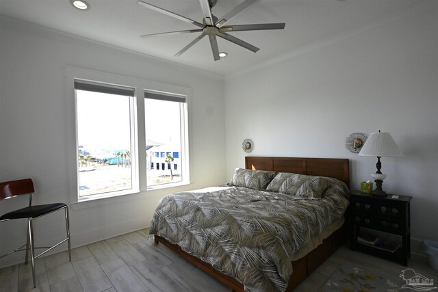 bedroom with hardwood / wood-style floors, ceiling fan, and crown molding