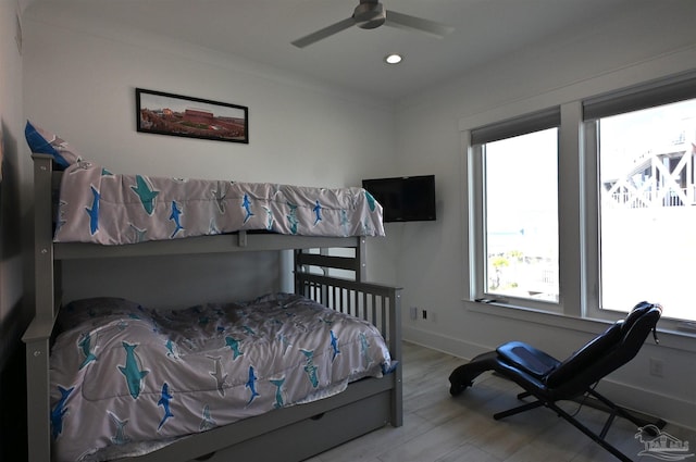 bedroom featuring ceiling fan, crown molding, and light hardwood / wood-style flooring