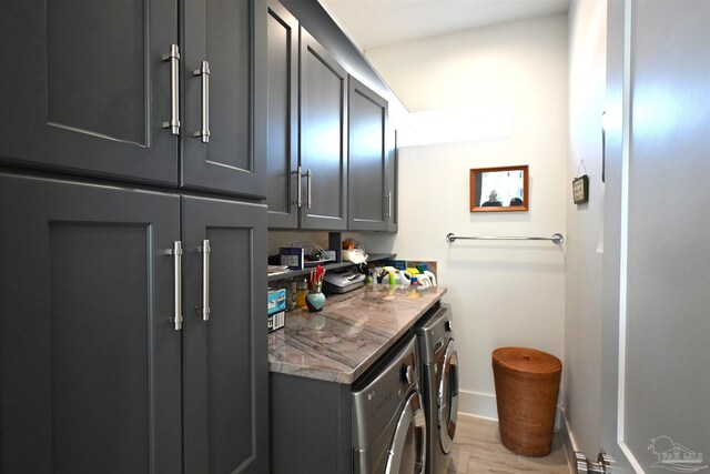 laundry room featuring light hardwood / wood-style floors, cabinets, and independent washer and dryer