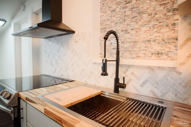 kitchen with island exhaust hood, sink, electric range, and backsplash