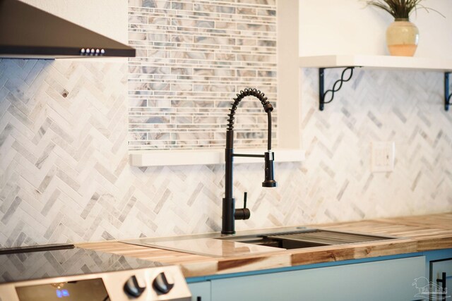 interior details with decorative backsplash, wooden counters, and wall chimney exhaust hood