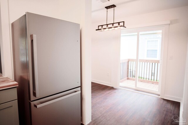 kitchen with gray cabinets, dark hardwood / wood-style floors, pendant lighting, and stainless steel fridge