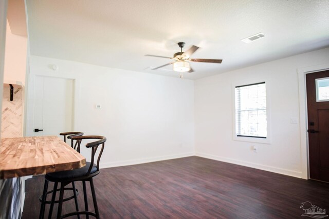 dining space with ceiling fan and dark hardwood / wood-style flooring