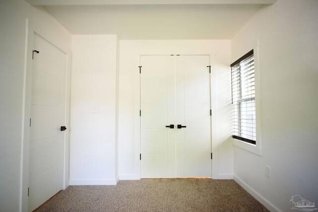 unfurnished bedroom with carpet and a closet