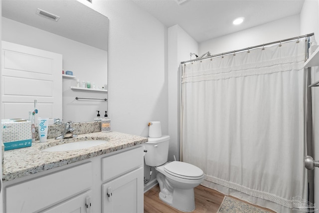 bathroom with a shower with shower curtain, vanity, wood-type flooring, and toilet