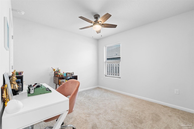 carpeted office featuring ceiling fan