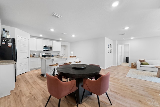 dining room featuring light hardwood / wood-style flooring and sink