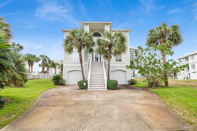 coastal inspired home with a garage and a front lawn