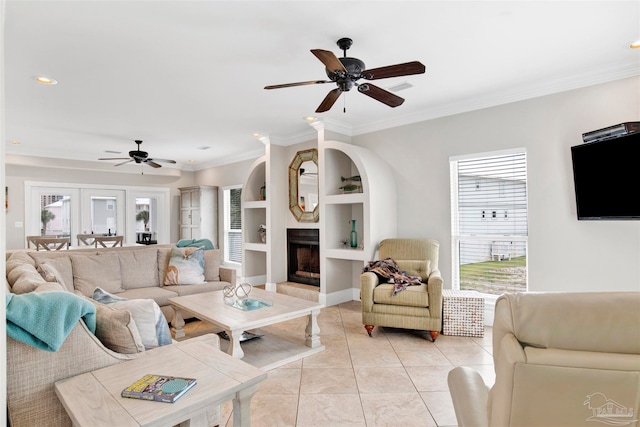 living room with built in features, ceiling fan, crown molding, and light tile patterned flooring