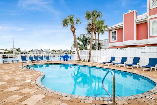 view of pool with a patio and a water view