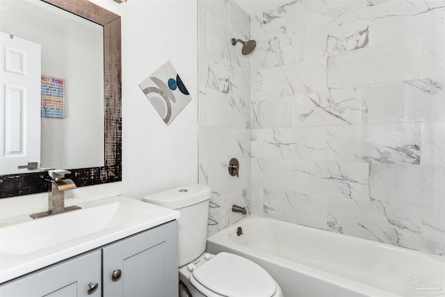 full bathroom featuring vanity, tiled shower / bath, and toilet