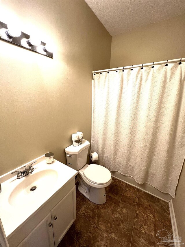 bathroom with vanity, a textured ceiling, and toilet