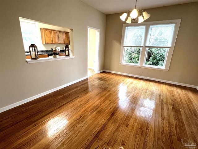 unfurnished dining area with light hardwood / wood-style flooring and a chandelier