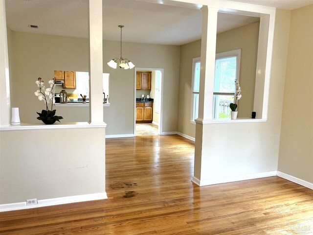 unfurnished dining area featuring light hardwood / wood-style flooring and a notable chandelier