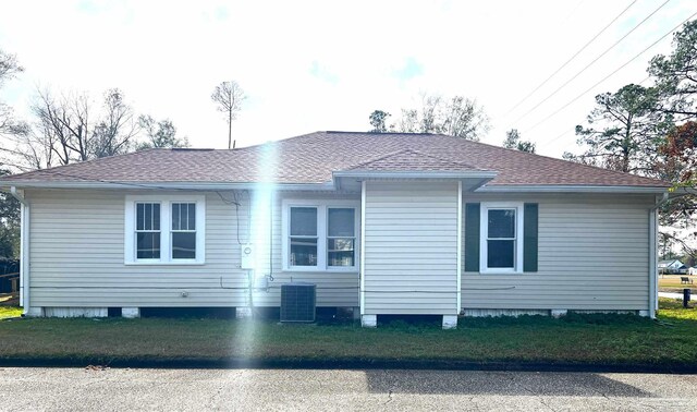 rear view of house with a yard and cooling unit