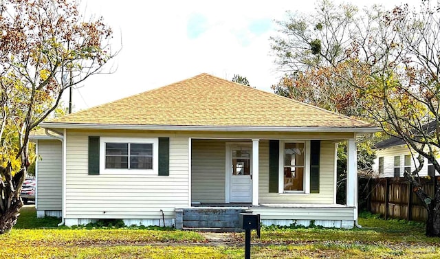 bungalow with covered porch and a front yard