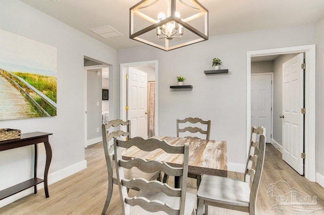 206 N G St, Pensacola, FL 32502 - dining area featuring light wood-type flooring, a chandelier, and baseboards