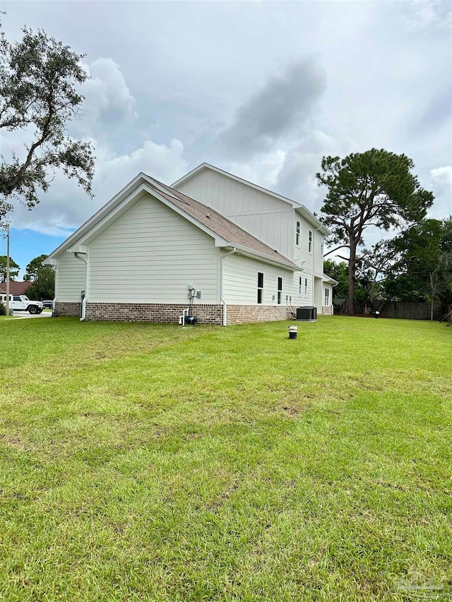 view of side of home featuring a lawn and cooling unit