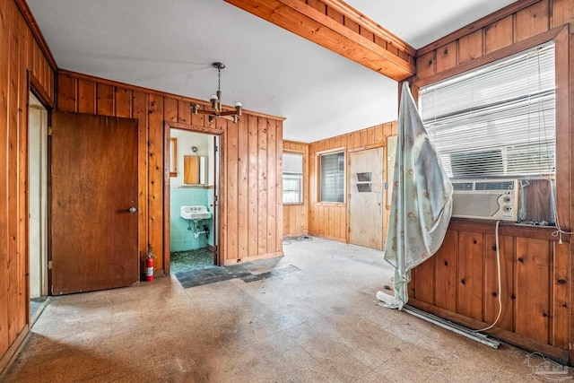 interior space with cooling unit, beamed ceiling, and wood walls