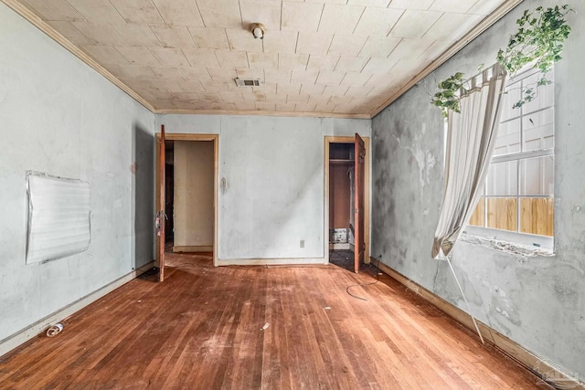 unfurnished room featuring wood-type flooring and ornamental molding