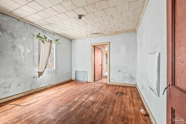 spare room featuring ornamental molding and hardwood / wood-style floors