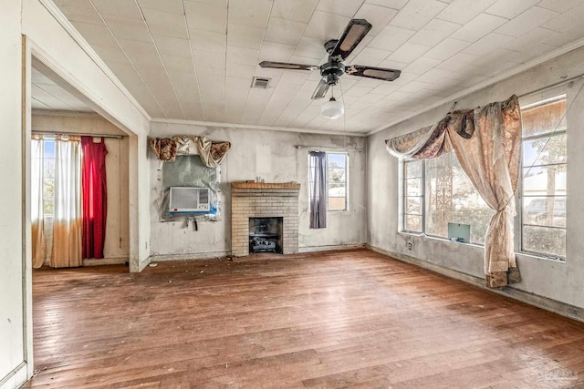 unfurnished living room with hardwood / wood-style flooring, ornamental molding, a brick fireplace, and ceiling fan