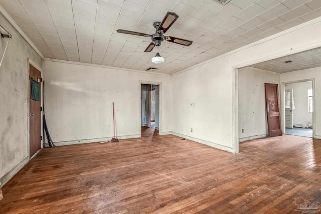 empty room featuring hardwood / wood-style floors, crown molding, and ceiling fan